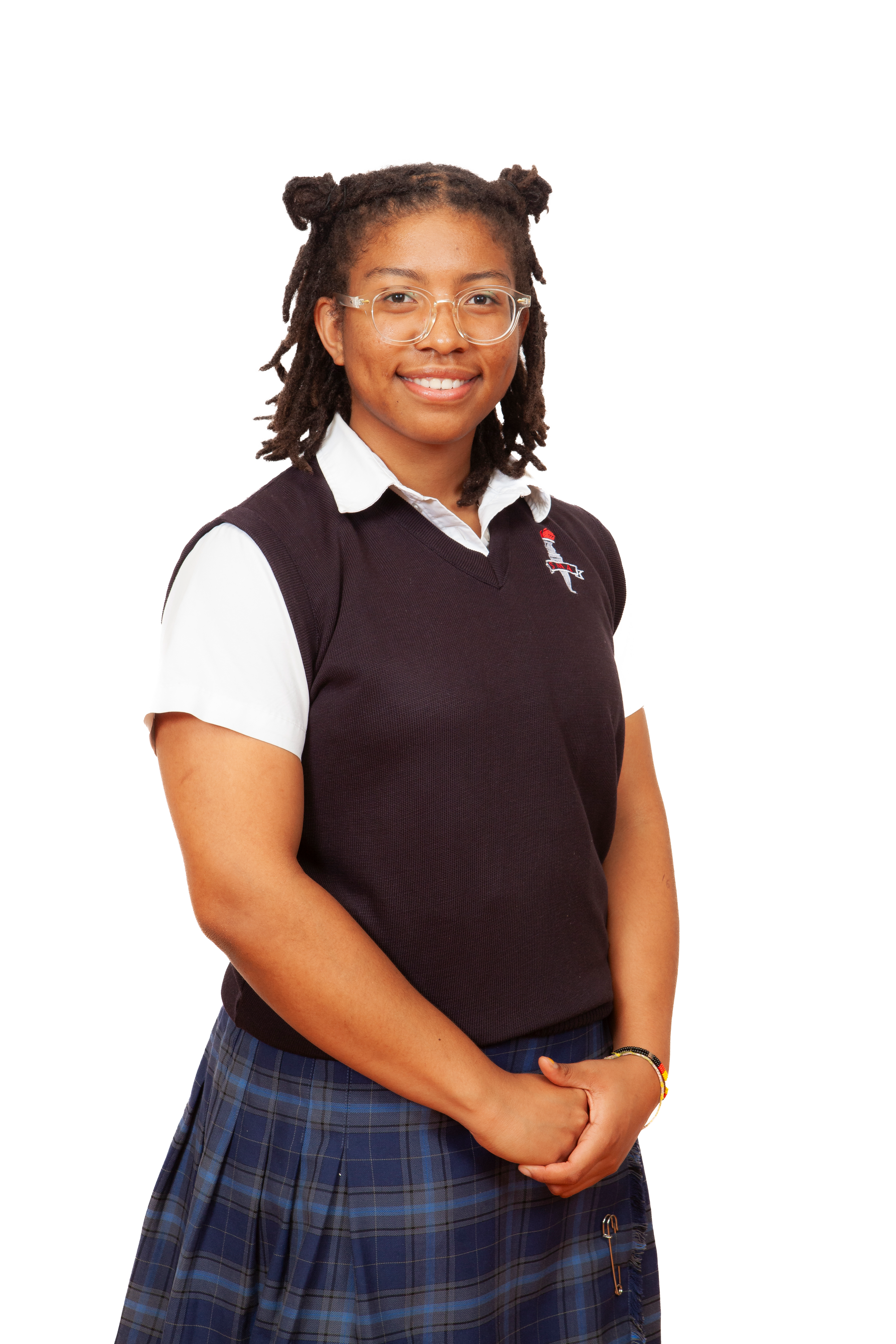 A uniformed student wears a plaid skirt, white button-down shirt and dark v-neck.