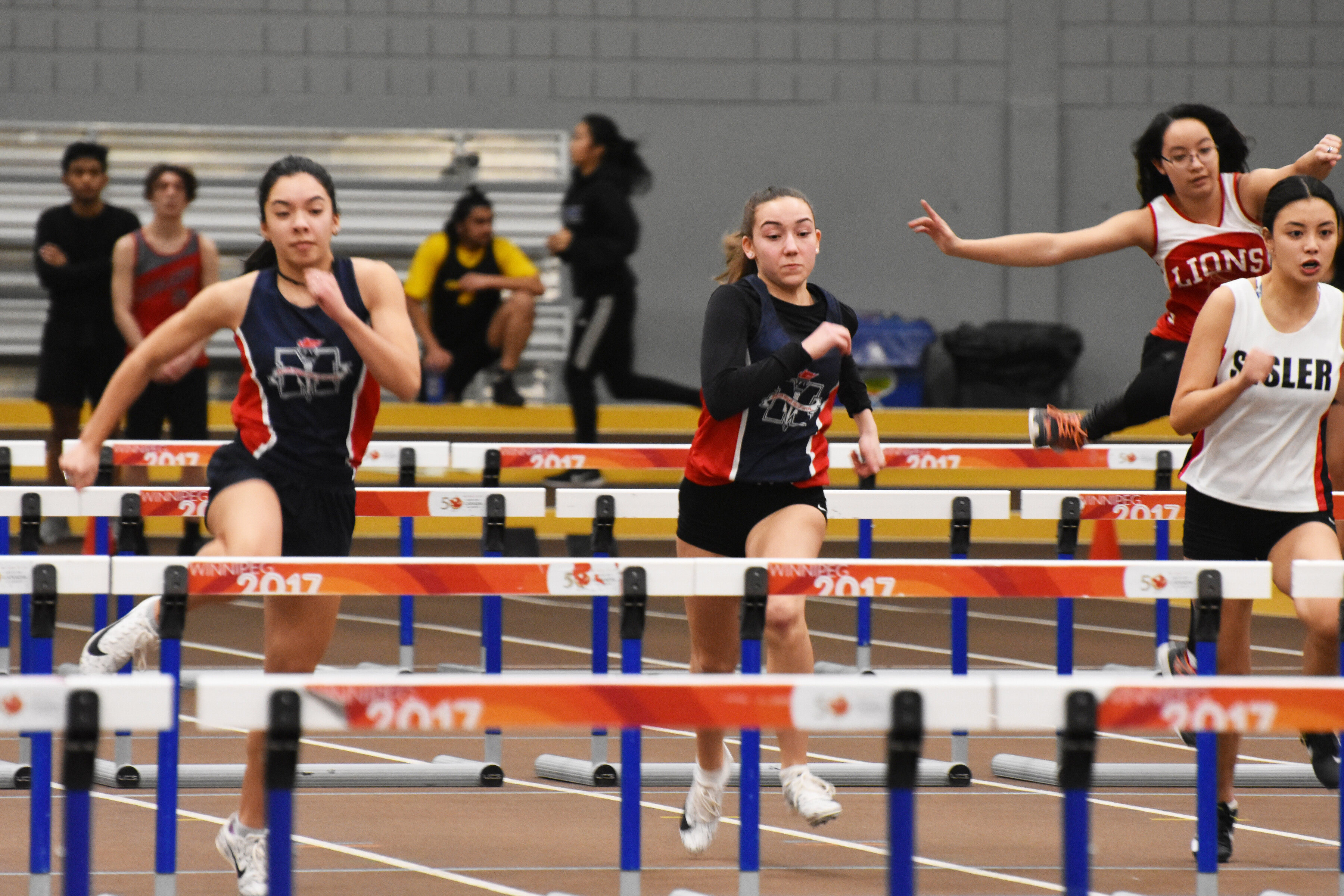 a group of women running in front of hurdles