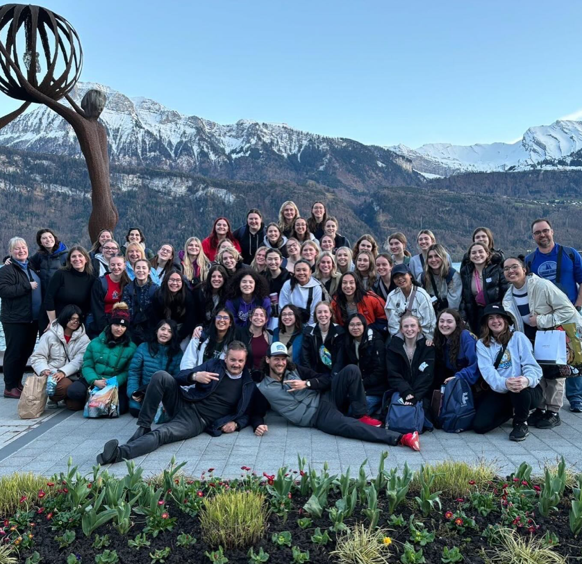 A large group of St. Mary's Academy students and adult chaperones stand outdoors.