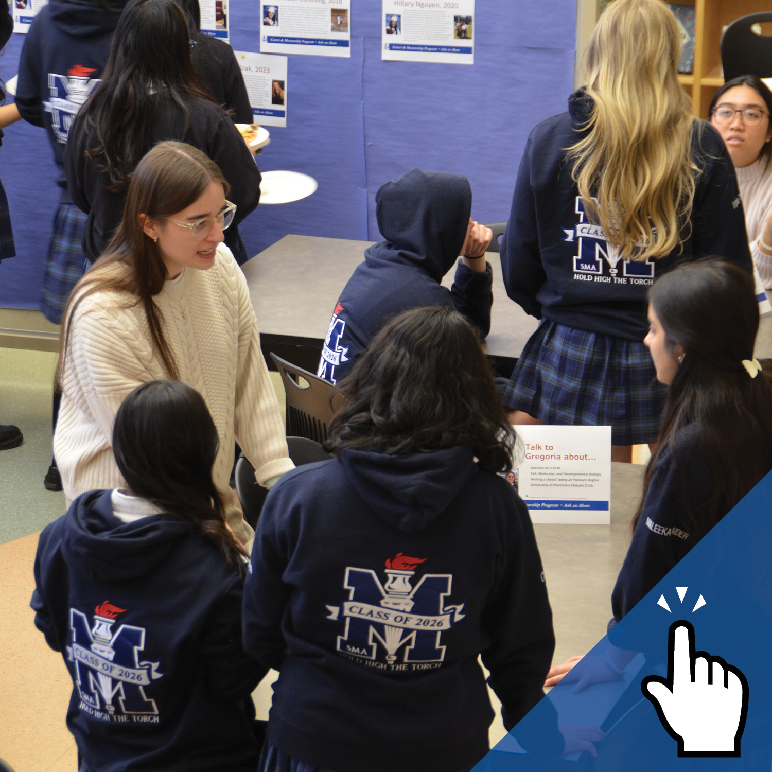 A group of St. Mary's Academy students talks to an alumnae inside a library