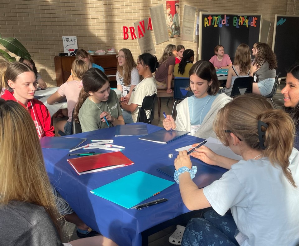 Female students sitting and doing arts and crafts on a table